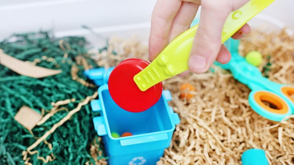 Recycling Sensory Bin child hand.